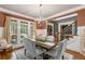 Bright dining room featuring a chandelier, large windows, and seating for six with views of the staircase at 5605 Copper Creek Pass, Cumming, GA 30040