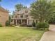 Beautiful home with manicured lawn and landscaping, showcasing a welcoming front porch and brick facade at 5605 Copper Creek Pass, Cumming, GA 30040
