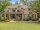 Charming brick home featuring manicured landscaping, a welcoming porch, and classic architectural details at 5605 Copper Creek Pass, Cumming, GA 30040