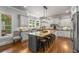 Sunlit kitchen featuring a large island with seating, stainless steel appliances, and beautiful natural views at 5605 Copper Creek Pass, Cumming, GA 30040