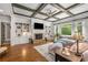 Bright living room with coffered ceiling, built-in shelving, stone fireplace, and large windows at 5605 Copper Creek Pass, Cumming, GA 30040