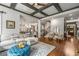 Open concept living room with hardwood floors, coffered ceiling, and elegant furnishings at 5605 Copper Creek Pass, Cumming, GA 30040