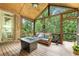 Cozy screened porch with wood ceilings, comfortable seating, and views of the surrounding greenery at 5605 Copper Creek Pass, Cumming, GA 30040