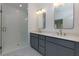 Modern bathroom with double vanity, elegant lighting, and a glass-enclosed shower at 302 Boxwood Ln, Roswell, GA 30075