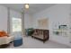 Bedroom featuring a crib, rocker, and neutral color palette with natural light at 302 Boxwood Ln, Roswell, GA 30075