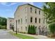 Beautifully detailed brick townhome with manicured lawn, shrubbery, and mature shade trees at 302 Boxwood Ln, Roswell, GA 30075