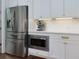 Modern stainless steel appliances including side by side refrigerator with cabinet surround and built-in microwave at 302 Boxwood Ln, Roswell, GA 30075