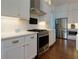 Well-equipped kitchen features stainless steel appliances, sleek white cabinets, and modern backsplash at 302 Boxwood Ln, Roswell, GA 30075