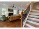 Bright open-concept living space with hardwood floors, fireplace, and staircase at 302 Boxwood Ln, Roswell, GA 30075