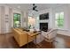 Living room with fireplace, plush seating, and hardwood floors bathed in natural light at 302 Boxwood Ln, Roswell, GA 30075