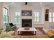 Comfortable living room with fireplace, built-in seating, and large windows at 302 Boxwood Ln, Roswell, GA 30075