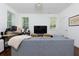 Bright and open living room with a large couch, desk, and natural light from shuttered windows at 302 Boxwood Ln, Roswell, GA 30075