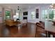 Open-concept living room with fireplace, dining area, hardwood floors, and large windows at 302 Boxwood Ln, Roswell, GA 30075