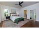 Bright main bedroom featuring an ensuite bathroom, a ceiling fan, and hardwood floors at 302 Boxwood Ln, Roswell, GA 30075