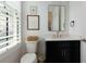 Stylish powder room featuring modern fixtures, a black vanity, and natural light from the window at 302 Boxwood Ln, Roswell, GA 30075