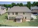 Back exterior of home shows a covered patio, brick, and an expansive grassy area at 332 Warwick Pl, Mcdonough, GA 30253