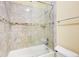 Bathroom with a bathtub and shower featuring tiled walls and a glass door at 332 Warwick Pl, Mcdonough, GA 30253