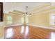 Spacious bedroom featuring hardwood floors, tray ceilings, a ceiling fan, and natural light from multiple windows at 332 Warwick Pl, Mcdonough, GA 30253