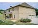 Rear view shows outdoor living space, brick, and a three-car garage on lush grounds at 332 Warwick Pl, Mcdonough, GA 30253