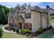 A beautiful two-story home featuring brick and stone exterior, with manicured lawn and lush landscaping at 332 Warwick Pl, Mcdonough, GA 30253