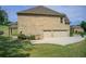 Exterior view with three-car garage, brick, and ample parking on landscaped grounds at 332 Warwick Pl, Mcdonough, GA 30253