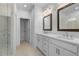 Bathroom featuring a glass shower, white cabinetry, dual sinks, and marble flooring at 5448 Howington E Ct # 194, Buford, GA 30518
