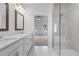Bathroom featuring a glass shower, dual sinks with white cabinets, and marble flooring leading to a bedroom at 5448 Howington E Ct # 194, Buford, GA 30518