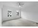 Bright, carpeted bedroom featuring two windows, a modern ceiling fan, and neutral tones at 5448 Howington E Ct # 194, Buford, GA 30518