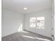 Well-lit room with window view, neutral carpet, and white walls at 5448 Howington E Ct # 194, Buford, GA 30518