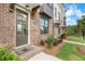 Charming brick townhome featuring a covered entrance and professionally landscaped front yard at 5448 Howington E Ct # 194, Buford, GA 30518