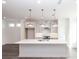 Bright kitchen boasts a large center island with pendant lighting, modern appliances and white cabinetry at 5448 Howington E Ct # 194, Buford, GA 30518