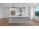Bright modern kitchen featuring a large island, stainless steel appliances and three pendant lights at 5448 Howington E Ct # 194, Buford, GA 30518