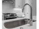Close-up of a kitchen sink with stainless steel faucet and modern appliances at 5448 Howington E Ct # 194, Buford, GA 30518