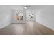 Bright open-concept living room with hardwood floors, ceiling fan, and large windows at 5448 Howington E Ct # 194, Buford, GA 30518