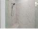 Close up of a modern shower with glass door, marble wall tiles and built in bench at 5448 Howington E Ct # 194, Buford, GA 30518
