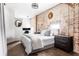 Bedroom featuring exposed brick, neutral colors, a decorative mirror and a desk area for work or study at 800 Peachtree Ne St # 8531, Atlanta, GA 30308