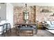 Open dining area with exposed brick wall, decorative lighting, modern furniture, and access to the living space at 800 Peachtree Ne St # 8531, Atlanta, GA 30308