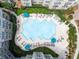 Aerial view of community pool with lounge chairs, umbrellas, lush landscaping, and multiple residential buildings at 800 Peachtree Ne St # 8531, Atlanta, GA 30308