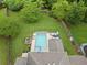 Aerial view of the backyard showcasing the in-ground pool, lush lawn, and surrounding mature trees at 1100 Carrington Pkwy, Villa Rica, GA 30180