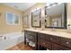 Bathroom featuring dual sinks, dark wood cabinets, and framed mirrors at 1100 Carrington Pkwy, Villa Rica, GA 30180