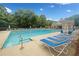 Community pool with several lounge chairs with umbrellas and clubhouse in the background at 1100 Carrington Pkwy, Villa Rica, GA 30180