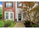 A welcoming entryway with a neatly landscaped garden and a charming black door with a wreath at 1100 Carrington Pkwy, Villa Rica, GA 30180