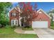 Charming two-story brick home featuring manicured lawn, two-car garage, and mature landscaping at 1100 Carrington Pkwy, Villa Rica, GA 30180