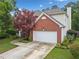 Brick and vinyl siding home featuring manicured lawn, two-car garage, and mature landscaping at 1100 Carrington Pkwy, Villa Rica, GA 30180