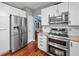 View of the stainless steel refrigerator and gas range/oven in this home's renovated kitchen at 1100 Carrington Pkwy, Villa Rica, GA 30180