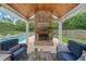 Inviting outdoor living area featuring a brick fireplace, outdoor seating, and a beautiful swimming pool at 1100 Carrington Pkwy, Villa Rica, GA 30180