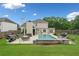 Backyard pool with a lounge area and a lush green lawn surrounded by a wooden fence at 1100 Carrington Pkwy, Villa Rica, GA 30180