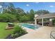 Inviting in-ground pool featuring a spa, covered patio with fireplace and comfortable outdoor seating, ideal for entertaining at 1100 Carrington Pkwy, Villa Rica, GA 30180