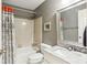 A bathroom featuring a tub with shower, gray walls, and a marble sink with a matching mirror above at 1386 Sheffield Glen Ne Way, Atlanta, GA 30329