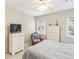 Bedroom with ceiling fan, white dresser, and wicker chair next to a bright window at 1386 Sheffield Glen Ne Way, Atlanta, GA 30329